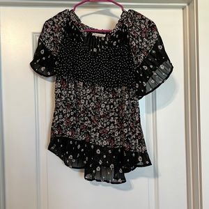 Small black blouse with white and red flower details.